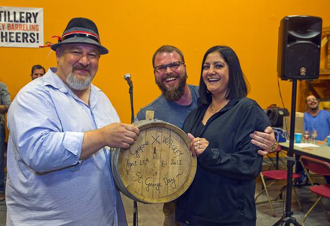 Distillery owner George Racz, left, poses with Rick and Sabrina Pond after the couple won a seven-gallon barrel of whiskey during the first St. George Day Spring Whiskey Barreling celebration at the Las Vegas Distillery in Henderson Saturday, April 25, 2015. Guests won free tickets to the drawing by participating in various activities.