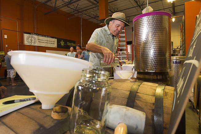 Bob Strodel, a CraftHaus Brewery investor, helps fill a barrel with whiskey during the first St. George Day Spring Whiskey Barreling celebration at the Las Vegas Distillery in Henderson Saturday, April 25, 2015. St. George's Day remembers Saint George, England's patron saint. The distillery owner and his son are also named George.
