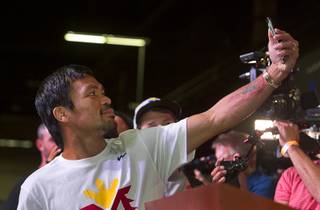 WBO welterweight champion Manny Pacquiao of the Philippines takes a selfie during a fan rally at the Mandalay Bay Tuesday, April 28, 2015. Pacquiao will face undefeated WBC/WBA welterweight champion Floyd Mayweather Jr. of the U.S. in a welterweight unification bout on May 2, 2015 at the MGM Grand Garden on Saturday.