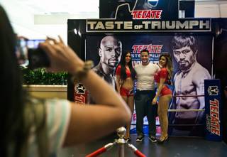 Fans get a few pictures with the Tecate Girls as they arrive for the grand arrival arrival of WBC/WBA welterweight champion Floyd Mayweather Jr. at MGM Grand Garden Arena on Tuesday, April 28, 2015.