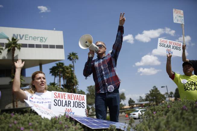 Michelle Balistreri and Chandler Gray attend a rally in front of NV Energy on Wednesday, April 22, 2015, in Las Vegas. Hundreds of activists gathered outside NV Energy headquarters in Las Vegas to protest a state cap affecting rooftop solar installations and urge the Legislature to lift it.