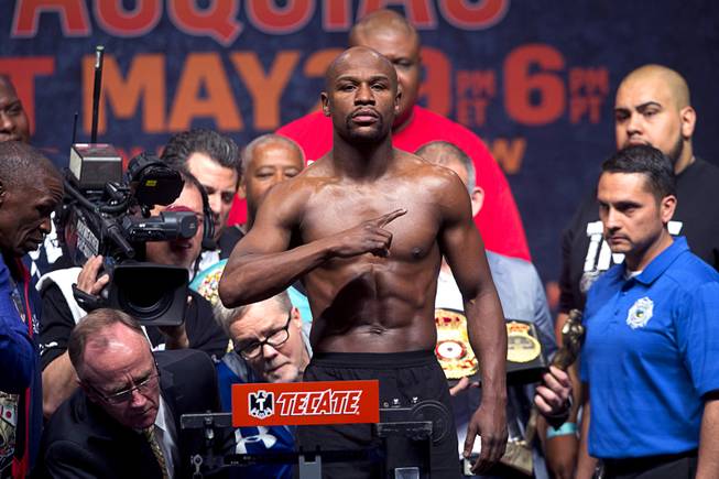 Undefeated WBC/WBA welterweight champion Floyd Mayweather Jr. poses on the scale during an official weigh-in at the MGM Grand Garden Arena Friday, May 1, 2015. Mayweather will face WBO welterweight champion Manny Pacquiao of the Philippines in a welterweight unification bout at the arena on Saturday.