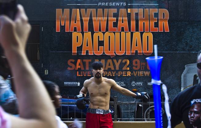 A man in a boxing outfit waits for photo possibilities while looking to make a quick buck outside the MGM Grand before the Floyd Mayweather versus Manny Pacquiao fight on Saturday, May 2, 2015.