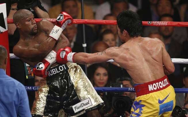 Manny Pacquiao, from the Philippines, right, hits Floyd Mayweather Jr. during their welterweight title fight on Saturday, May 2, 2015 in Las Vegas.