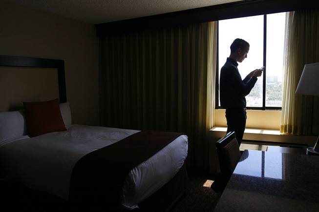 12:38 p.m. - Las Vegas Sun reporter J.D. Morris checks his phone for messages after arriving at his room in the Riviera Sunday, May 3, 2015.  