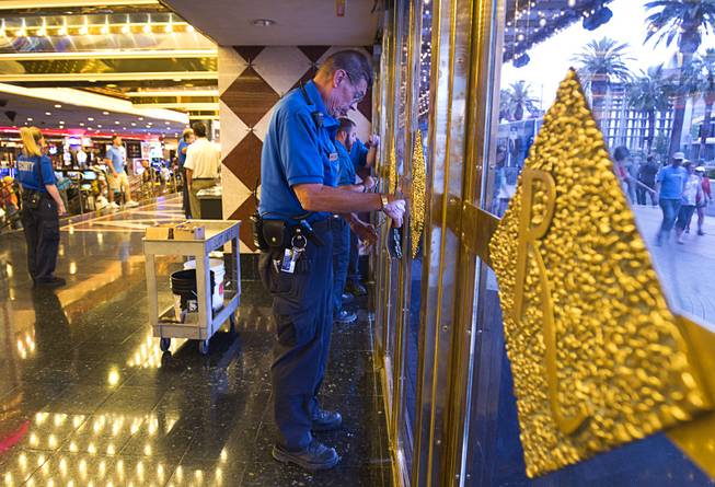 11:59 a.m. - A security officer starts chaining the front doors of the Riviera Monday, May 4, 2015. The 60-year-old Riviera, which was the Las Vegas Strip's first high-rise property, will be imploded to make way for a $2.3 billion convention center business district facility.