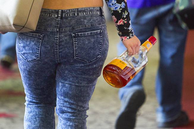 9:36 a.m. - A woman leaves with a bottle of alcohol at the Riviera Monday, May 4, 2015.