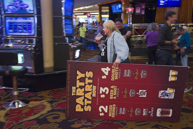 12:13 p.m. - A woman leaves with a promotion sign as the Riviera closes Monday, May 4, 2015.  STEVE MARCUS