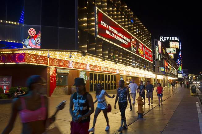 Pedestrians pass by the Riviera early Monday morning, May 4, 2015. The 60-year-old Riviera, which was the Las Vegas Strips first high-rise property, will be imploded to make way for a $2.3 billion convention center business district facility.