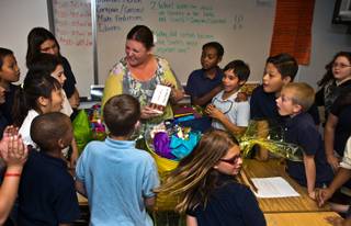 Fifth-grade teacher Jessica Flynn at C.T. Sewell Elementary shows her students what is in the gift basket she received after presented with one of CCSD's annual New Educator of the Year awards on Wednesday, May 6, 2015.