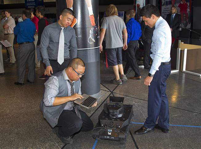 Tony Teoh, standing left, Rong Xue, center, and Brian Kieatiwong work on their Autonomous Security Robot after blowing a Bluetooth module during the Fred and Harriet Cox Senior Design Competition at UNLV Thursday, May 7, 2015. The robot uses localized tracking  and can travel autonomously to the designated coordinates even if the Wi-Fi signal is lost, students said.