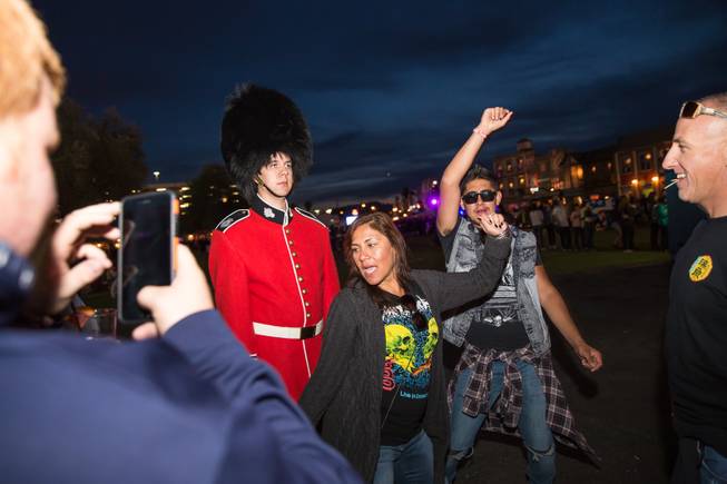 A couple attempts to make a Queens Guard crack a smile during Rock in Rio Las Vegas, Friday May 8, 2015.