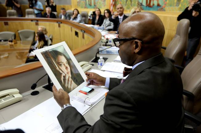 State Sen. Isadore Hall, D-Compton, looks at a photo of Brittany Maynard as lawmakers take testimony on proposed legislation allowing doctors to prescribe life-ending medication to terminally ill patients, at the Capitol on Wednesday, March 25, 2015, in Sacramento, Calif.