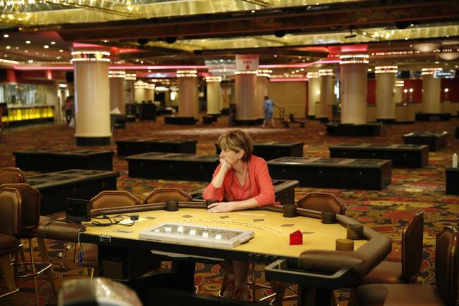 A woman who declined to give her name, sits at a table in the casino during a liquidation sale at the closed Riviera Hotel and Casino Thursday, May 14, 2015, in Las Vegas. The Riviera Hotel and Casino closed May 4, but everything inside the 2,075-room hotel-casino must go. National Content Liquidators has started selling it all at a public sale that started 9 a.m. Thursday.