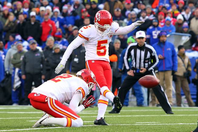 In this Nov. 9, 2014, file photo, Kansas City Chiefs kicker Cairo Santos, with Dustin Colquitt holding, kicks an extra point against the Buffalo Bills during an NFL football game in Orchard Park, N.Y. The NFL is moving back extra-point kicks and allowing defenses to score on 2-point conversion turnovers. 