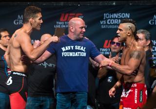 UFC middleweight champion Chris Weidman responds verbally to contender Vitor Belfort while being separated by president Dana White during their UFC 187 weigh ins at the MGM Grand Ballroom on Friday, May 22, 2015.