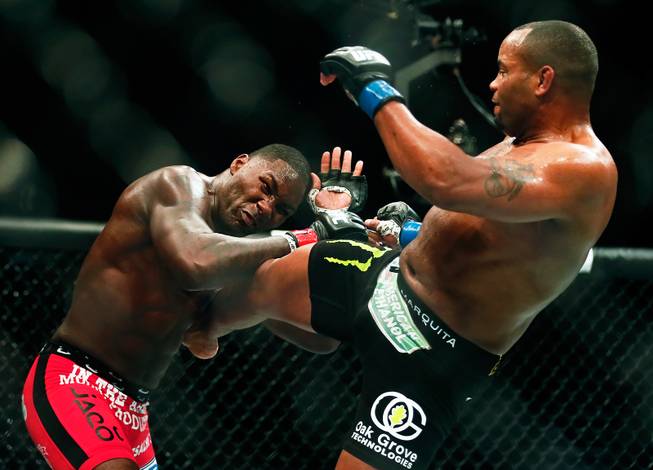 UFC light heavyweight contender Anthony Johnson takes a hard kick to the ribs by opponent Daniel Cormier during their UFC 187 fight at the MGM Grand Garden Arena on Friday, May 22, 2015.