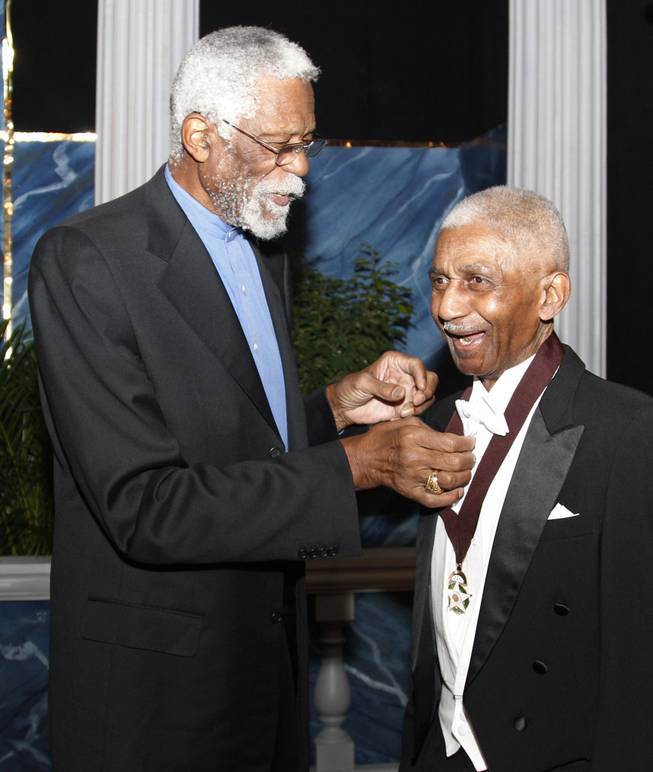 Former NBA star Bill Russell, left, adjusts the medal hanging from Marques Haynes' neck on Nov. 17, 2011, as they pose for a photo before induction ceremonies for the Oklahoma Hall of Fame in Oklahoma City. Haynes died Friday in Plano, Texas. He was 89.
