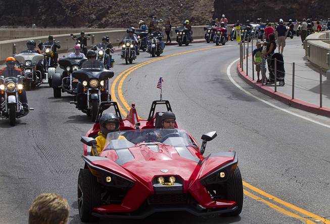 A three-wheeled trike passes over Hoover Dam during the annual Flags Over the Dam parade from the dam to the Southern Nevada Veterans Memorial Cemetery Sunday, May 24, 2015. At the cemetery, a service was conducted by the Special Forces Association, Chapter 51, with assistance from various Vietnam veterans motorcycle clubs.