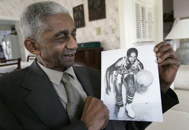 Former Harlem Globetrotters great Marques Haynes holds a photo circa 1951 of himself in his Globetrotters uniform Thursday, Feb. 14, 2008, in Plano, Texas. Haynes played in the legendary game 60 years ago, Feb. 19, 1948, when the Globetrotters beat the Minneapolis Lakers and their big man, George Mikan, 61-59 at Chicago Stadium.