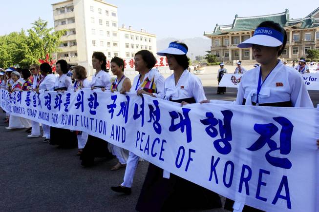 International women activists march through Kaesong City in North Korea on Sunday, May 24, 2015. Female activists including Gloria Steinem and two Nobel Peace laureates were denied an attempt to walk across the Demilitarized Zone dividing North and South Korea on Sunday but were allowed to cross by bus and complete what one of them called a landmark event.