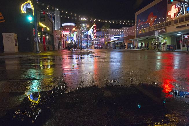 Rain puddles are shown on East Fremont Street in downtown Las Vegas Sunday, May 24, 2015.