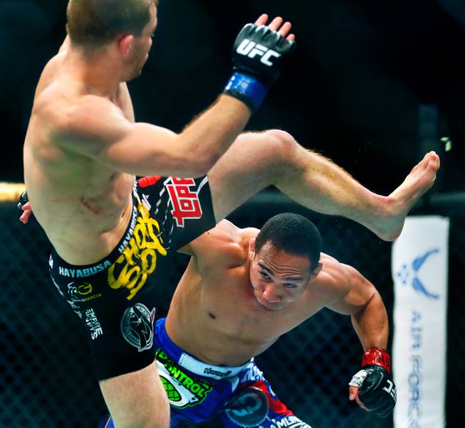 UFC flyweight contender John Dodson ducks under a sweeping kick by contender Zach Makovsky during their UFC 187 fight at the MGM Grand Garden Arena on Friday, May 22, 2015.