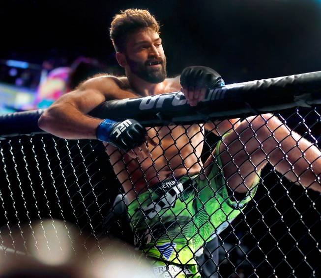 UFC heavyweight contender Andre Arlovski celebrates atop the octagon after beating opponent Travis Browne during their UFC 187 fight at the MGM Grand Garden Arena on Friday, May 22, 2015.