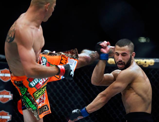UFC lightweight contender Donald Cerrone throws a kick to the head of contender John Makdessi absorbing some of the blow during their UFC 187 fight at the MGM Grand Garden Arena on Friday, May 22, 2015.