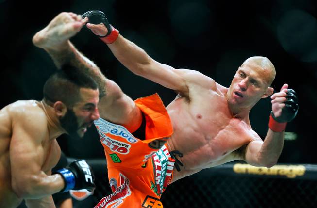 UFC lightweight contender John Makdess takes a glancing kick to the head by opponent Donald Cerrone during their UFC 187 fight at the MGM Grand Garden Arena on Friday, May 22, 2015.