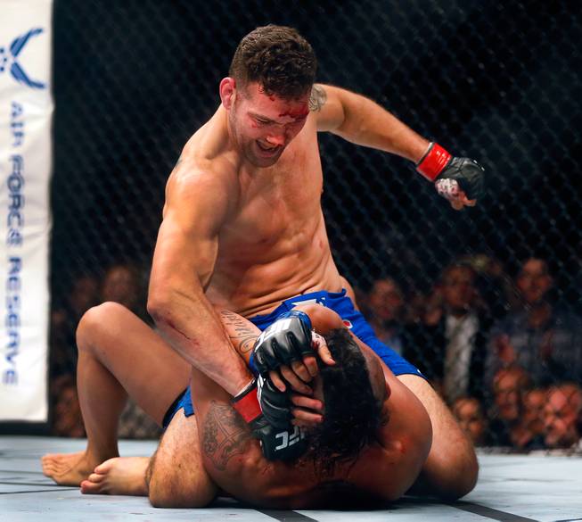 UFC middleweight champion Chris Weidman continues a barrage of punches as he dominates contender Vitor Belfort on the canvas during their UFC 187 fight at the MGM Grand Garden Arena on Friday, May 22, 2015.