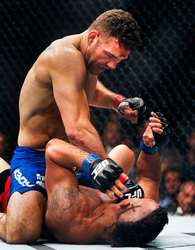 UFC middleweight champion Chris Weidman continues a barrage of punches as he dominates contender Vitor Belfort on the canvas ending their UFC 187 fight at the MGM Grand Garden Arena on Friday, May 22, 2015.