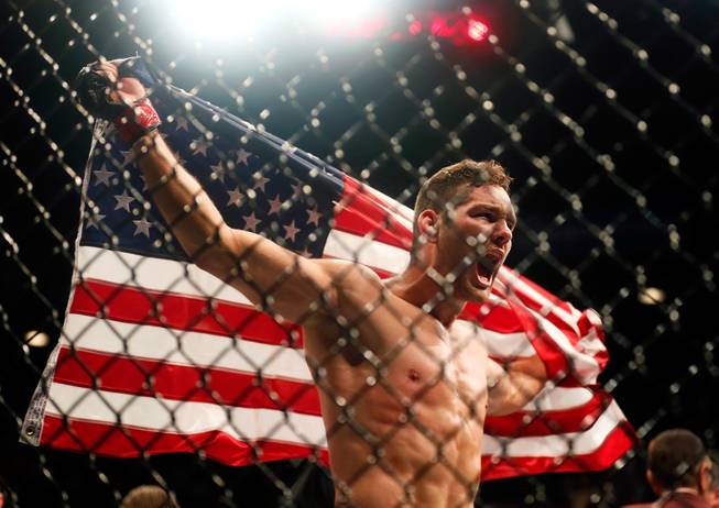 UFC middleweight champion Chris Weidman celebrates his first-round win over contender Vitor Belfort following their UFC 187 fight at the MGM Grand Garden Arena on Friday, May 22, 2015.