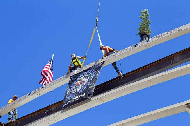 Steelworkers Mike Dyke and Jason Luis climb onto the final steel beam during a topping off ceremony for the Las Vegas Arena Wednesday, May 27, 2015. Representatives from MGM Resorts International and AEG, contractors Hunt-Penta and elected officials were on hand to celebrate the installation of the arena's final steel beam. The $375 million arena is scheduled to open in Spring 2016.