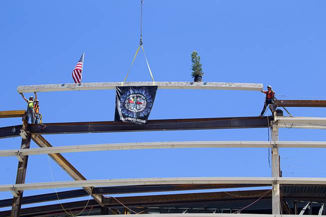 Steelworkers guide the final steel beam into place during a topping off ceremony for the Las Vegas Arena Wednesday, May 27, 2015. Representatives from MGM Resorts International and AEG, contractors Hunt-Penta and elected officials were on hand to celebrate the installation of the arena's final steel beam. The $375 million arena is scheduled to open in Spring 2016.