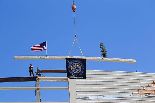 The final steel beam is lifted into place during a topping off ceremony for the Las Vegas Arena Wednesday, May 27, 2015. Representatives from MGM Resorts International and AEG, contractors Hunt-Penta and elected officials were on hand to celebrate the installation of the arena's final steel beam. The $375 million arena is scheduled to open in Spring 2016.