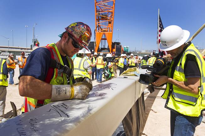Ironworker Kody Clary signs the final steel beam during a topping off ceremony for the Las Vegas Arena Wednesday, May 27, 2015. Representatives from MGM Resorts International and AEG, contractors Hunt-Penta and elected officials were on hand to celebrate the installation of the arena's final steel beam. The $375 million arena is scheduled to open in Spring 2016.