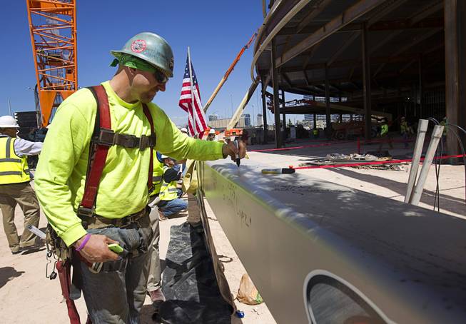 Ironworker Preston Mills signs the final steel beam during a topping off ceremony for the Las Vegas Arena Wednesday, May 27, 2015. Representatives from MGM Resorts International and AEG, contractors Hunt-Penta and elected officials were on hand to celebrate the installation of the arena's final steel beam. The $375 million arena is scheduled to open in Spring 2016.