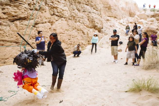 Melissa Gonzalez swings at a pinata during Justin Favela's Family Fiesta at Michael Heizer's Double Negative located in the Moapa Valley on Mormon Mesa near Overton, Nevada on May 9, 2015.