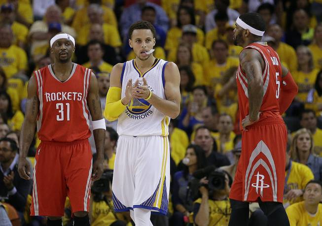 Golden State Warriors guard Stephen Curry (30) stands between Houston Rockets guard Jason Terry (31) and forward Josh Smith (5) during the first half of Game 5 of the NBA basketball Western Conference finals in Oakland, Calif., Wednesday, May 27, 2015.