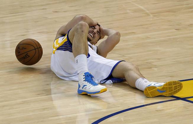 Golden State Warriors guard Klay Thompson lies on the court after being injured during the second half of Game 5 of the NBA basketball Western Conference finals against the Houston Rockets in Oakland, Calif., Wednesday, May 27, 2015. 