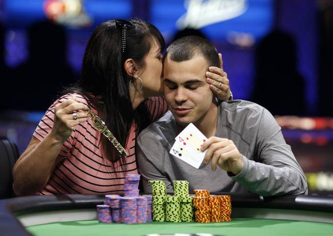 Lance 'Cord' Garcia gets a kiss from his mother, Kristen Scott, while posing for photographers after he won the World Series of Poker Colossus event Wednesday, June 3, 2015, in Las Vegas.