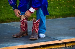 Senior Cody Snider puts on his boots in the parking lot before graduation at Indian Springs High School north of Las Vegas on Thursday, June 4, 2015.