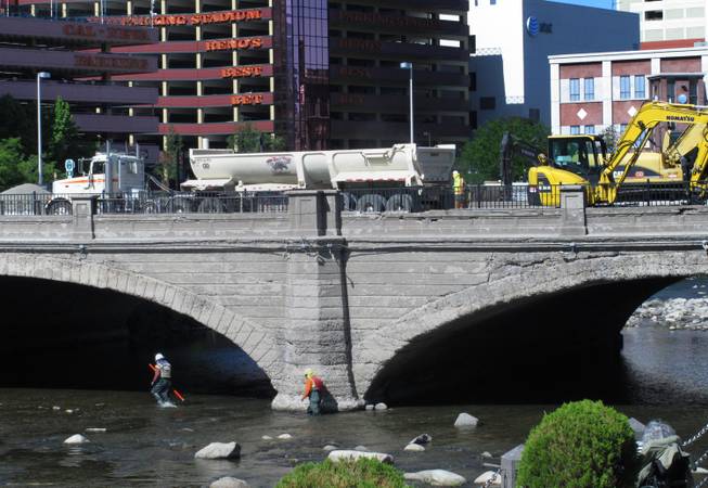 Crews work June 2 on top of the Virginia Street Bridge in downtown Reno and in the Truckee River below in preparation for demolition of the bridge, which was built in 1905. It's being replaced by a modern span as part of a major flood-control project and is expected to open in May.