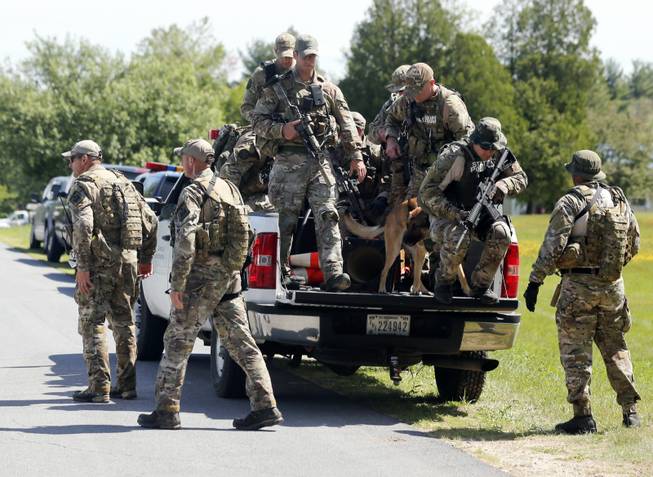 Law enforcement officers get off a truck as they return to their vehicles after searching a wooded area Sunday, June 14, 2015, in Schuyler Falls, N.Y. Law enforcement personnel are in the ninth day of searching for David Sweat and Richard Matt, two killers who used power tools to cut their way out of Clinton Correctional Facility in Dannemora in northern New York.