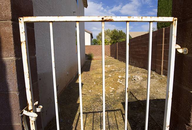 The side yard of a foreclosed home is shown in a neighborhood near Tenaya Way and Russell Road Thursday, June 25, 2015. The yard has been recently cleared of weeds.