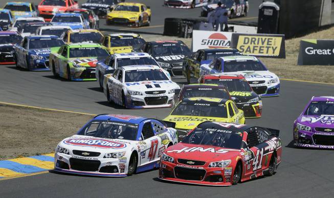 A.J. Allmendinger (47) and Kurt Busch (41) drive through Turn 2 at the start of the NASCAR Sprint Cup Series auto race Sunday, June 28, 2015, in Sonoma, Calif.