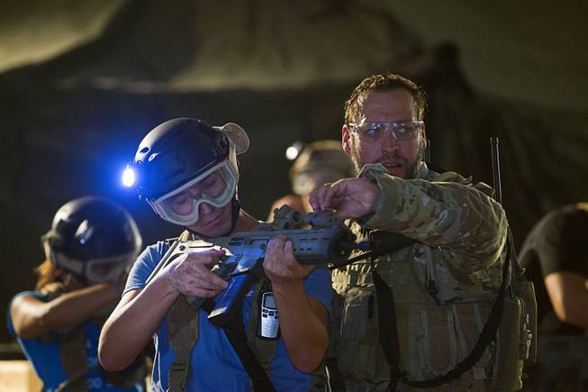 Team Leader Neptune adjusts a laser sight for a participant before an operation at Adventure Combat Ops, 4375 S. Valley View Blvd., Monday, June 29, 2015. The zombie-apocalypse-combat experience opens on July 2.