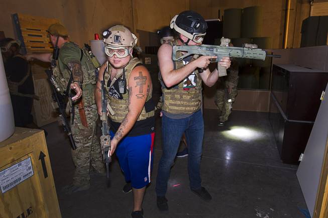 Participants learn how to cover doors in preparation for an operation at Adventure Combat Ops, 4375 S. Valley View Blvd., Monday, June 29, 2015. The zombie-apocalypse-combat experience opens on July 2.