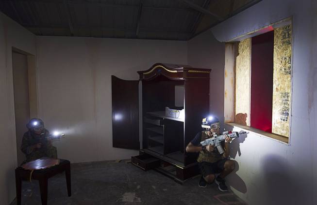 Participants secure a window during an operation at Adventure Combat Ops, 4375 S. Valley View Blvd., Monday, June 29, 2015. The zombie-apocalypse-combat experience opens on July 2.